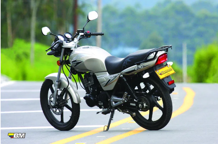 Moto AKT EVO 125 de color blanco estacionada en plena vía