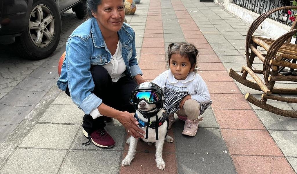 Maylo, el perrito motero posando junto a una señora y a una niña.