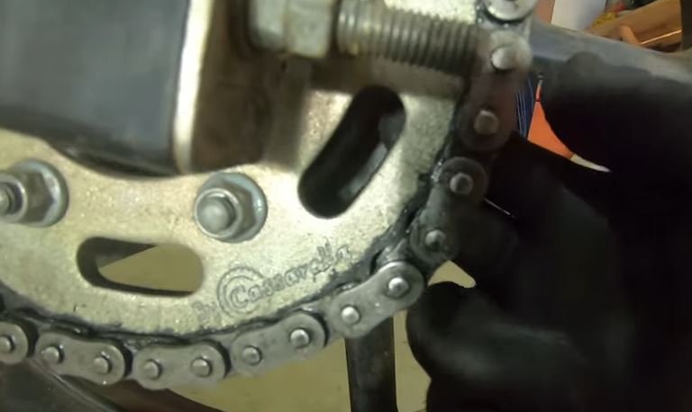 prueba de despegue de la cadena Cuándo reemplazar el kit de arrastre de tu moto: 7 señales que debes identificar 5 Imagen de una prueba de despegue de cadena de una moto para ver la holgura de la cadena con el sprocket