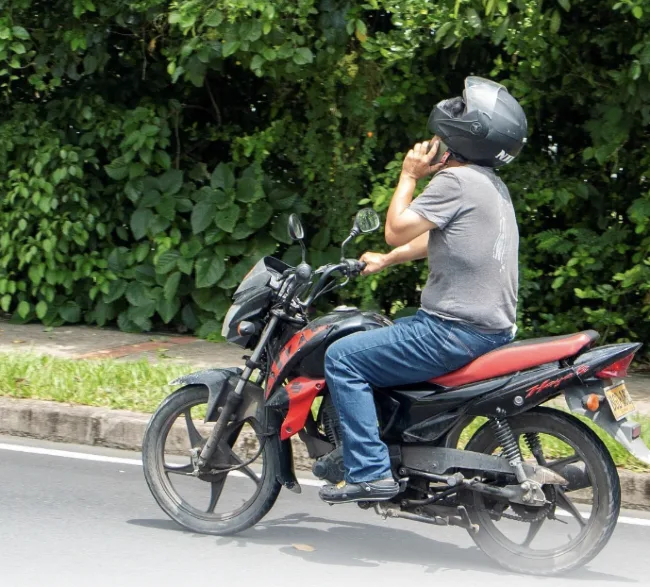 motociclista hablando por telefono 10 errores al conducir una moto que pueden terminar en un accidente 4 Hablar por teléfono mientras conduces es uno de los errores al conducir una moto